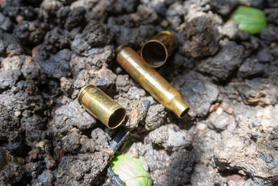 High angle view of bullets on rocks