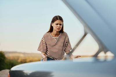 Portrait of young woman sitting on railing