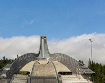 View of bridge and buildings against cloudy sky