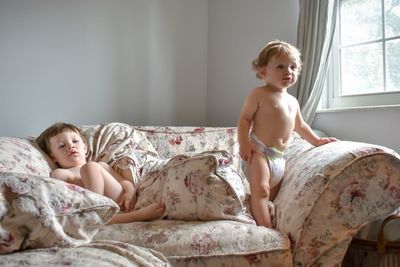 Boy sitting on bed at home