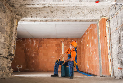 Full length of manual worker looking at ceiling