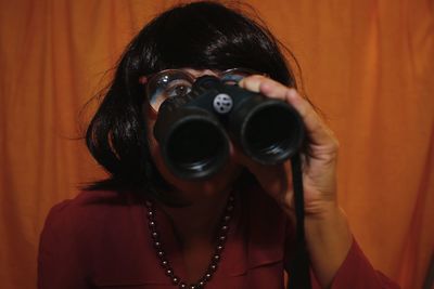 Close-up of mature woman looking through binoculars