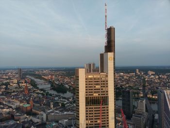 High angle view of city buildings against cloudy sky