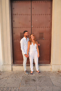 Happy young couple standing in city