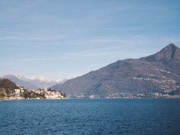 Scenic view of sea by mountains against sky