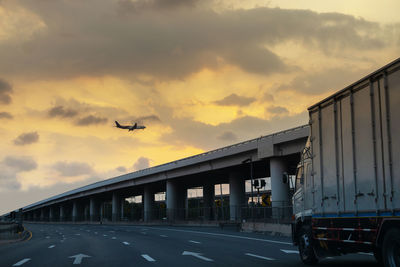 Bridge over road against sky during sunset