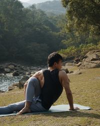 Side view of woman sitting on rock