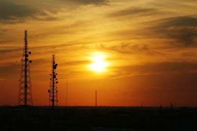 Silhouette electricity pylon against sky during sunset