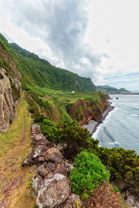 Scenic view of sea and mountains against sky