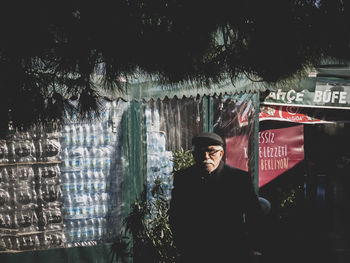 Man standing by text against trees