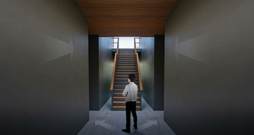 Rear view of woman walking in corridor of building