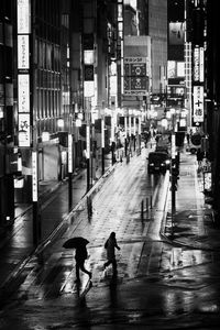 People walking on city street at night