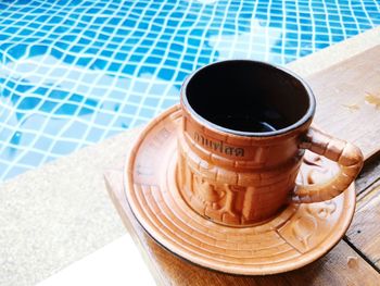 High angle view of coffee on table at swimming pool