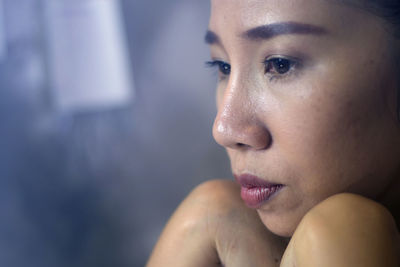 Close-up portrait of young woman looking away