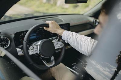 Man holding steering wheel sitting in electric car