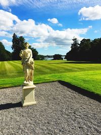 Statue by tree against sky