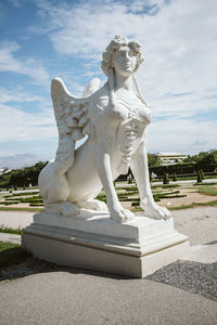 Statue of angel in park against sky