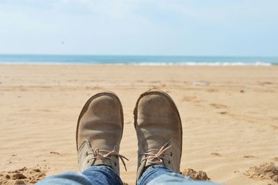 Low section of man standing on beach