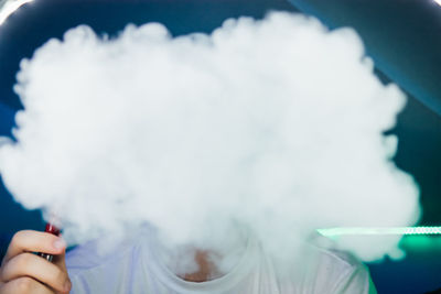 Close-up of young man smoking in club