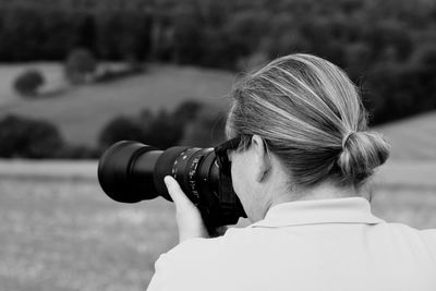 Rear view of woman photographing camera