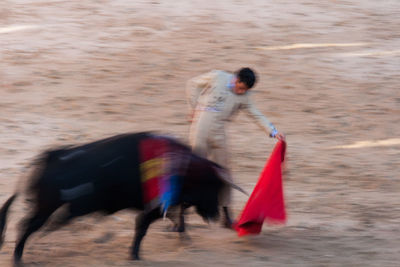 Blurred motion of man running on sand