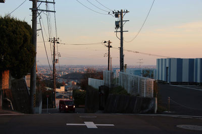 Street amidst buildings against sky during sunset