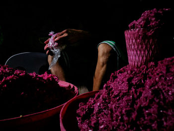 Midsection of market vendor selling shrimp paste at street market during night