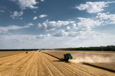 Agricultural machinery on field against sky