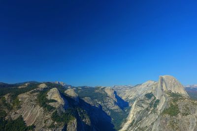 Panoramic view of mountains against clear blue sky