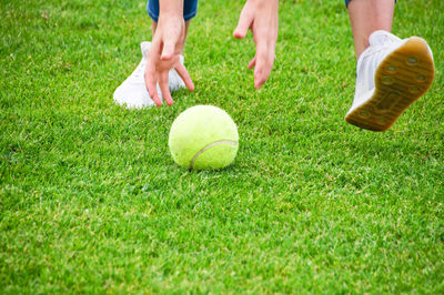 Low section of woman playing with ball on field