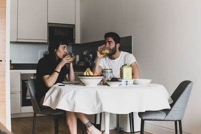 Young couple sitting on table at home