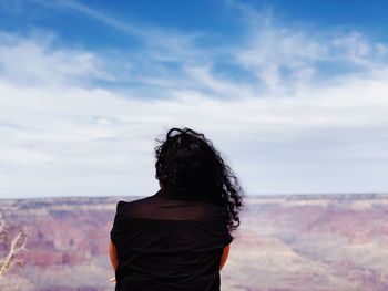 Rear view of woman standing against sky