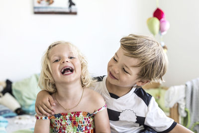 Portrait of happy siblings at home