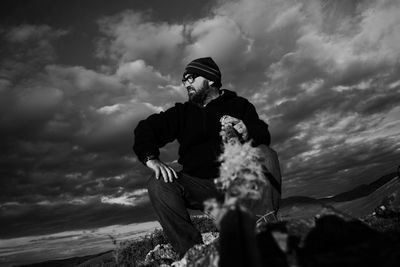 Rear view of man sitting on mountain