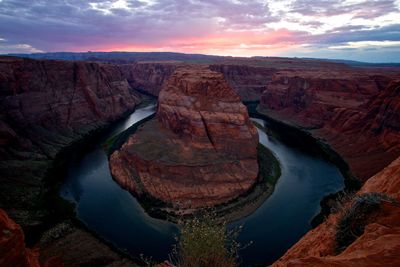 Scenic view of horseshoe bend against sky during sunset