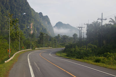 Asphalt road through the mountain with fog accross the mountain