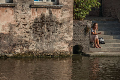 Woman sitting by the lake