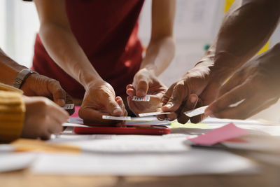 Midsection of business colleagues working on table