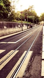 View of railroad tracks by road in city