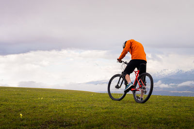 Professional mountain biker on the background of mountains and green hills. tired mtb rider in full