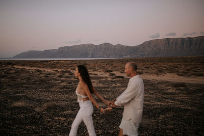 Friends standing on land against sky