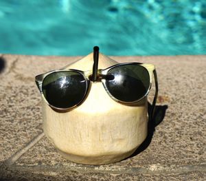 Close-up of coconut wearing sunglasses in swimming pool