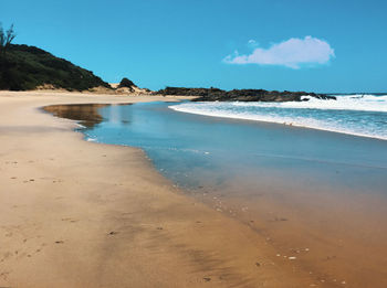 Scenic view of beach against blue sky