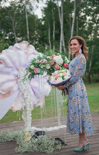 Portrait of smiling young woman holding bouquet