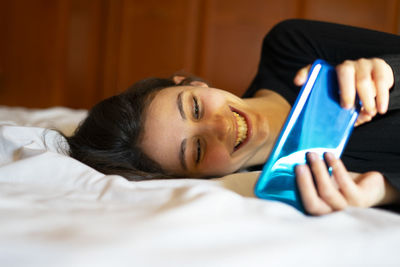 Woman playing a mobile game in bed.