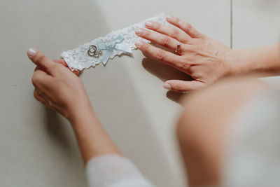 Cropped hands of woman holding paper