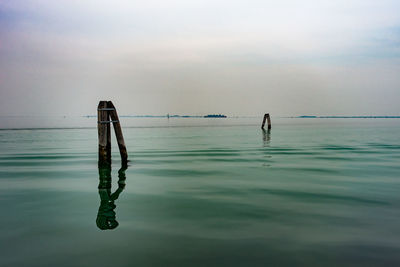 Man swimming in sea against sky