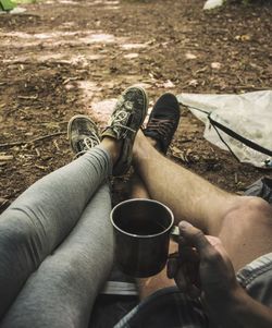 Low section of couple camping in forest