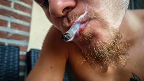 Close-up of man smoking cigarette outdoors