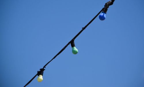 Low angle view of lamp post against clear blue sky